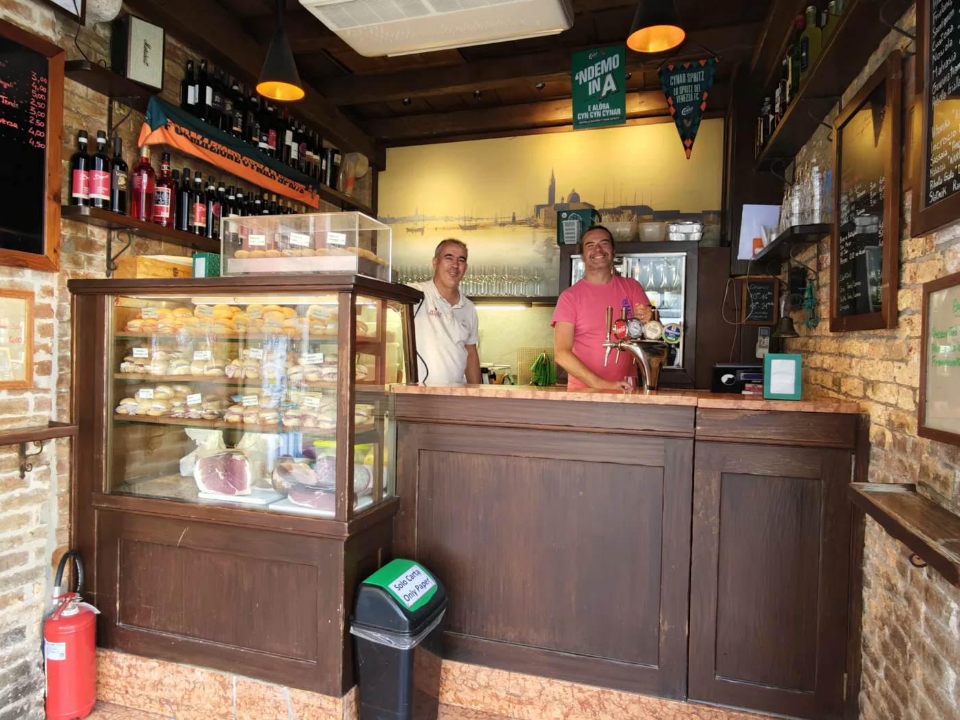 Inside the Al Mercà bacaro with the cicchetti display case and the marble counter, at Rialto in Venice